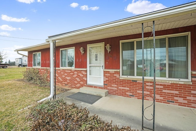 view of exterior entry featuring a yard