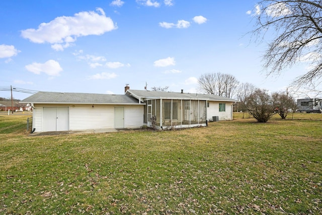 rear view of property with a yard and a sunroom