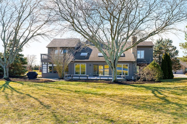 rear view of house with a balcony and a lawn