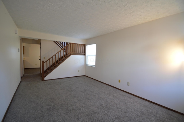 carpeted spare room featuring a textured ceiling