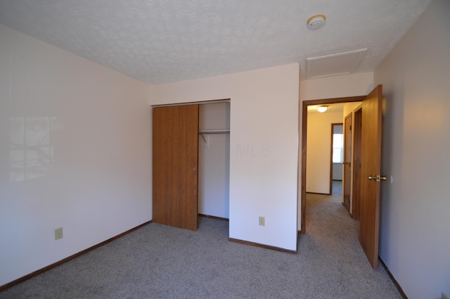 unfurnished bedroom featuring a closet, carpet floors, and a textured ceiling