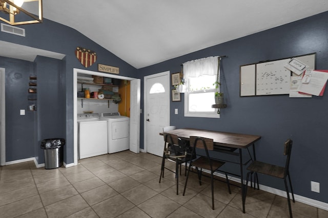 tiled dining area featuring an inviting chandelier, separate washer and dryer, and vaulted ceiling