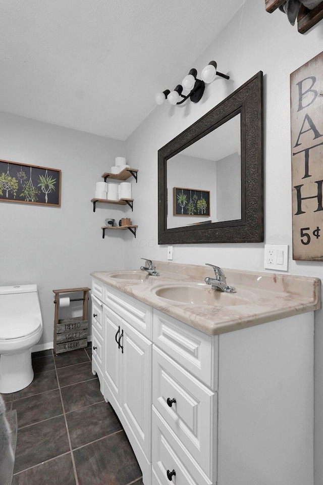 bathroom with vanity, tile patterned floors, and toilet