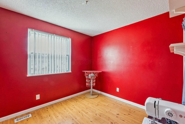 empty room featuring hardwood / wood-style flooring and a textured ceiling