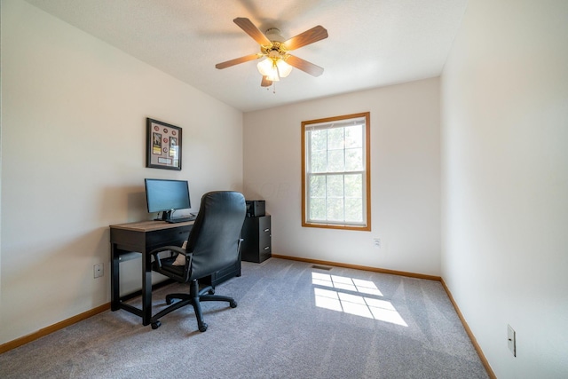 carpeted office space featuring ceiling fan