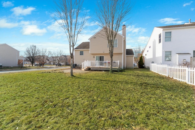 back of property featuring a wooden deck and a yard