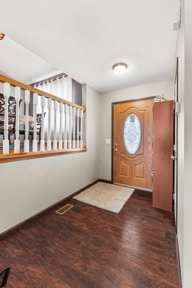 entrance foyer featuring dark wood-type flooring and a textured ceiling