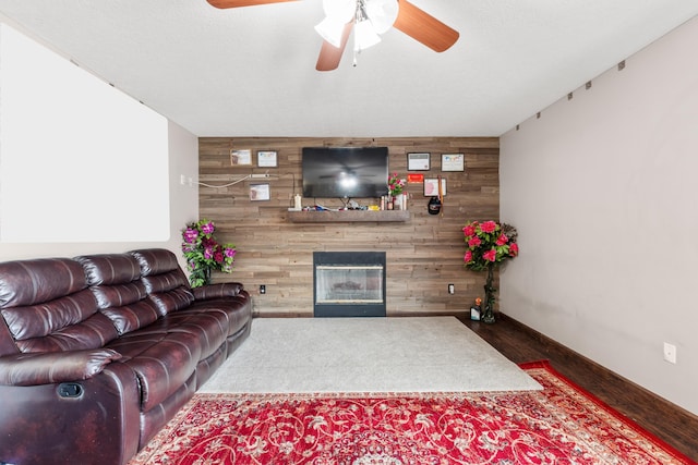 living room with wood-type flooring, a textured ceiling, a fireplace, and wood walls