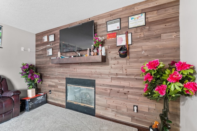 living room with wood walls, carpet, and a textured ceiling