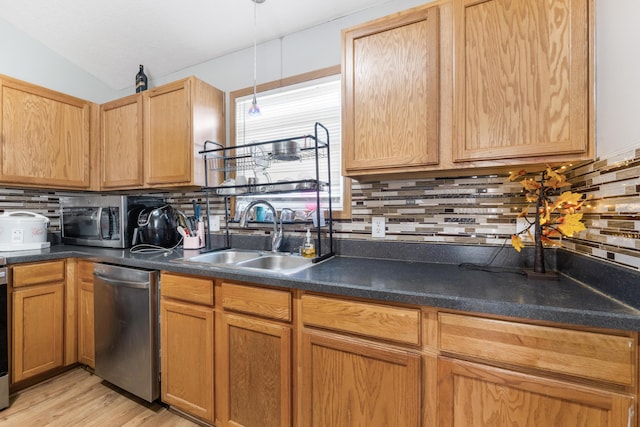 kitchen featuring vaulted ceiling, sink, decorative backsplash, stainless steel appliances, and light hardwood / wood-style flooring