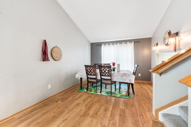 dining room featuring lofted ceiling and light wood-type flooring