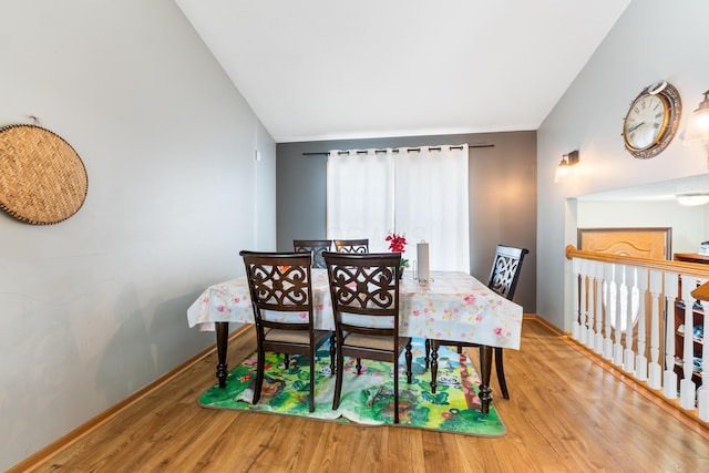 dining space featuring hardwood / wood-style flooring and lofted ceiling