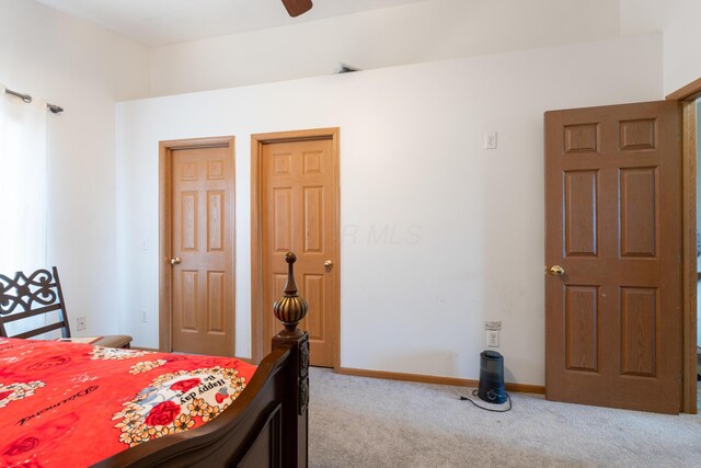 bedroom featuring multiple closets and light carpet