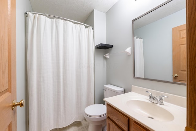 bathroom with vanity, toilet, and a textured ceiling