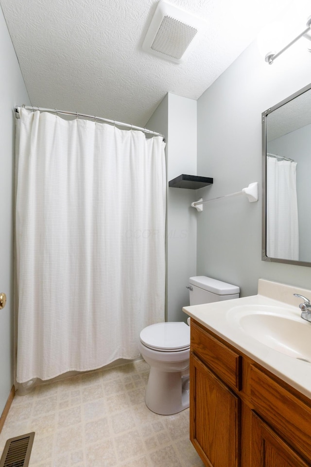 bathroom featuring vanity, toilet, and a textured ceiling