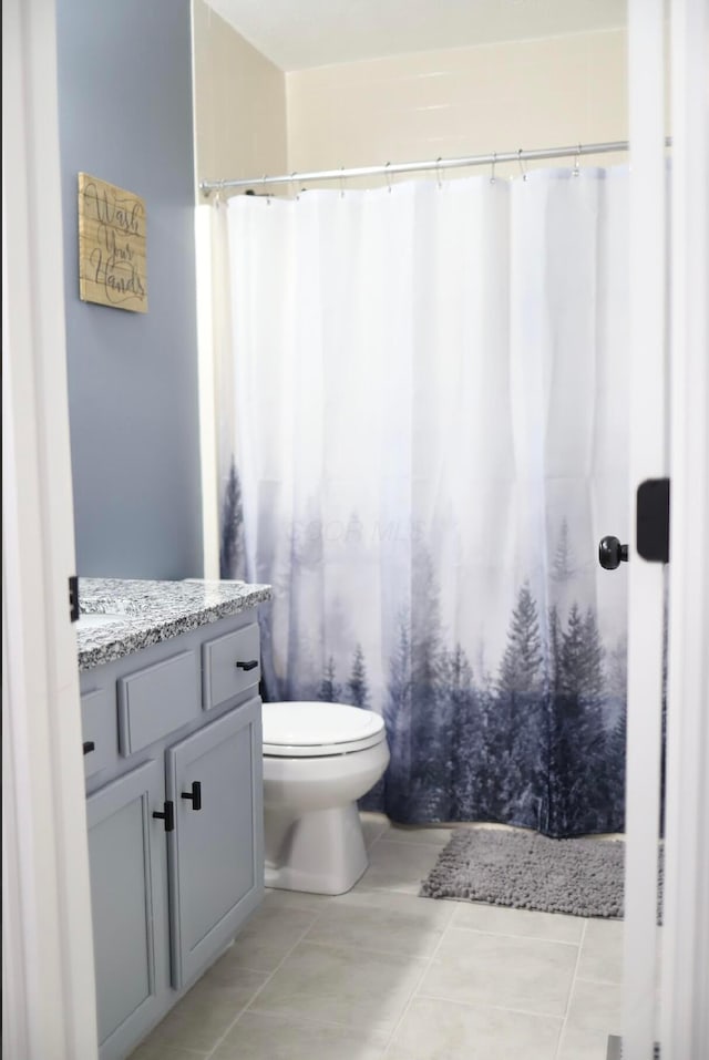 bathroom featuring tile patterned flooring, vanity, and toilet