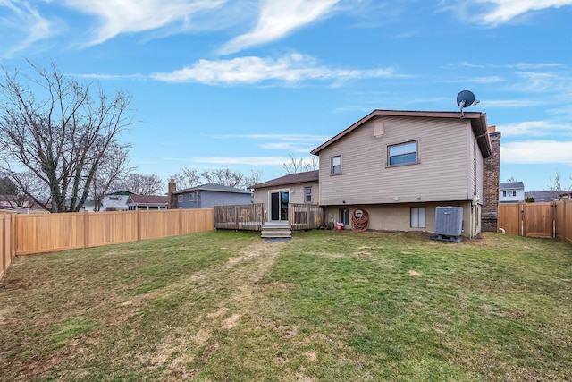 back of house with a fenced backyard, a lawn, a wooden deck, and central air condition unit