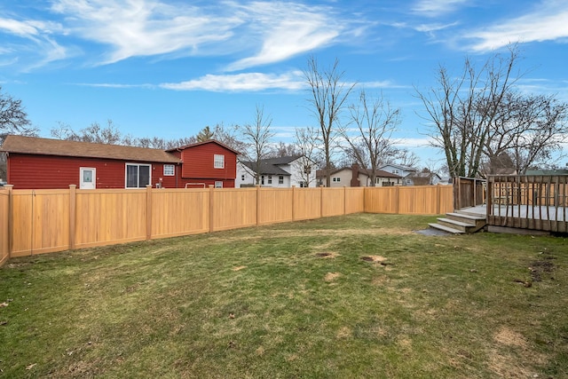 view of yard featuring a wooden deck, a fenced backyard, and a residential view