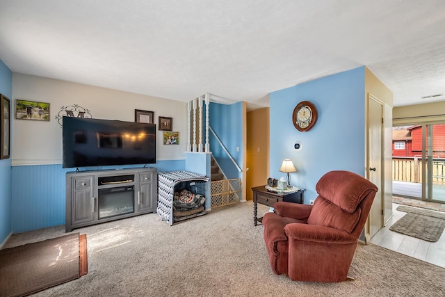 living room with stairs, carpet floors, wainscoting, and visible vents