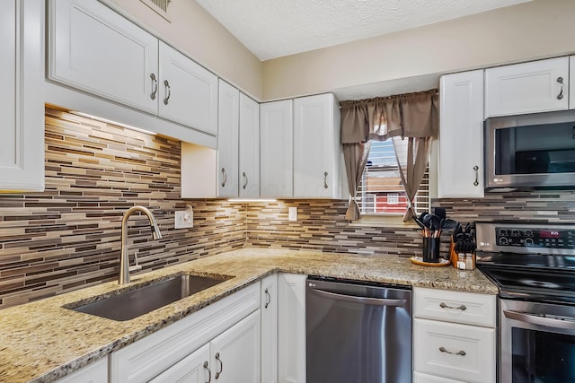 kitchen with white cabinetry, appliances with stainless steel finishes, and a sink