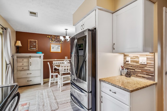 kitchen with tasteful backsplash, visible vents, smart refrigerator, an inviting chandelier, and white cabinetry