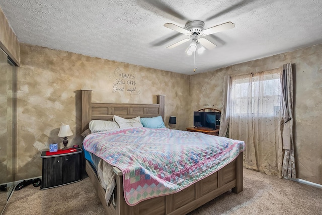 bedroom featuring carpet floors, a ceiling fan, and a textured ceiling