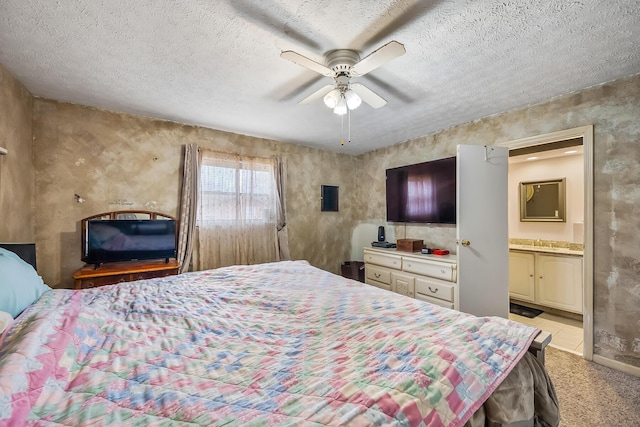 bedroom with a textured ceiling, ceiling fan, light carpet, and ensuite bath