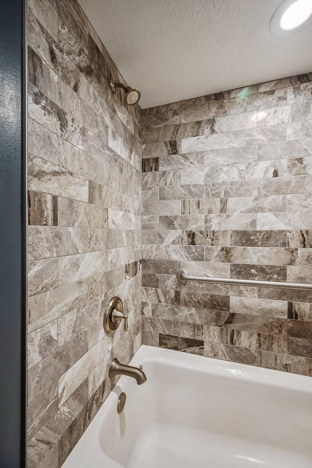 full bath with shower / bathing tub combination and a textured ceiling