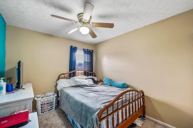 bedroom featuring a textured ceiling, carpet flooring, a ceiling fan, and baseboards