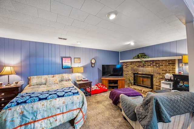 carpeted bedroom featuring a fireplace and visible vents