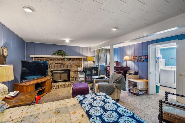 living room featuring washer / clothes dryer, carpet, and a brick fireplace