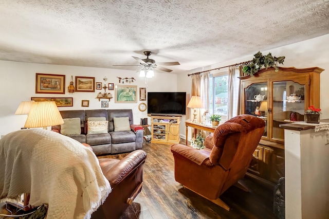 living room with dark wood-type flooring, ceiling fan, and a textured ceiling