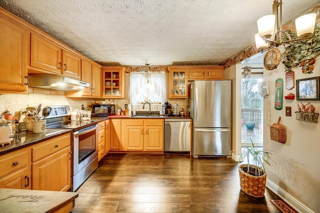 kitchen featuring pendant lighting, sink, appliances with stainless steel finishes, dark hardwood / wood-style floors, and tasteful backsplash