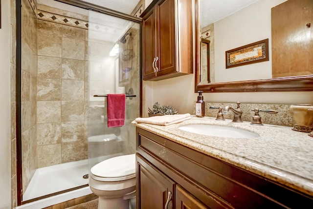 bathroom with vanity, a shower with shower door, and toilet