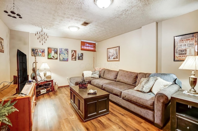 living room featuring light hardwood / wood-style floors and a textured ceiling