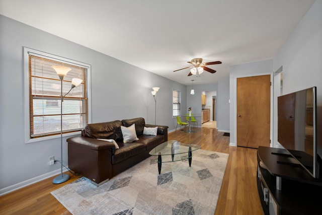 living room featuring ceiling fan, light hardwood / wood-style flooring, and a healthy amount of sunlight