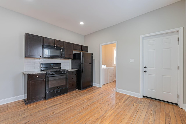 kitchen featuring washing machine and clothes dryer, dark brown cabinetry, light hardwood / wood-style floors, decorative backsplash, and black appliances