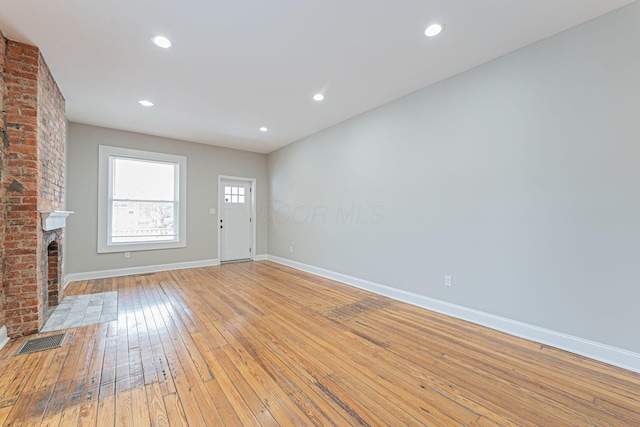 unfurnished living room featuring a fireplace and light wood-type flooring