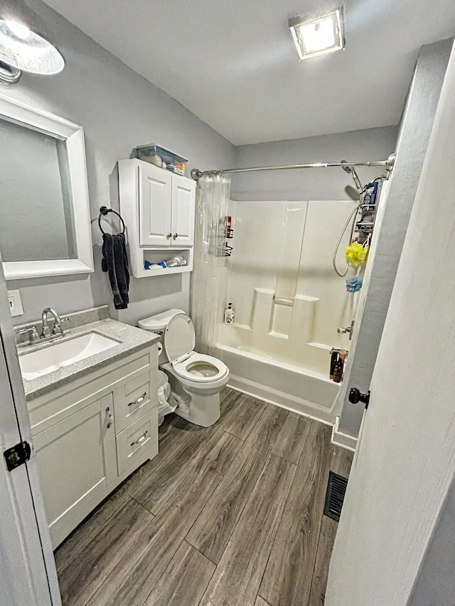 full bathroom with toilet, hardwood / wood-style floors, vanity, and shower / bath combo with shower curtain