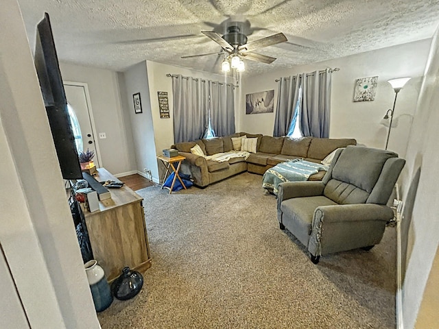 carpeted living room featuring ceiling fan and a textured ceiling