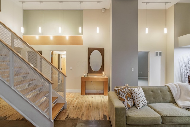 interior space featuring a towering ceiling and wood-type flooring