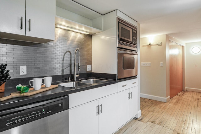 kitchen with white cabinetry, appliances with stainless steel finishes, sink, and tasteful backsplash