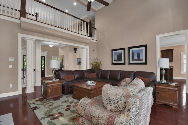 living room featuring crown molding, ceiling fan, decorative columns, a high ceiling, and dark hardwood / wood-style flooring