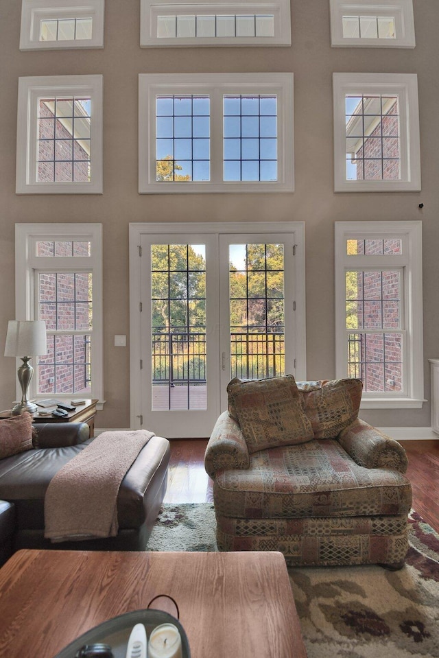 living room with a towering ceiling and hardwood / wood-style floors