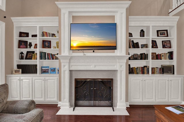 living room with dark hardwood / wood-style flooring and built in shelves