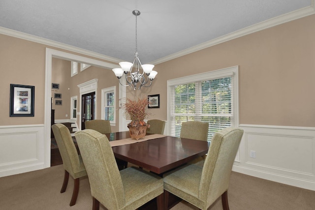 carpeted dining room with ornamental molding and a notable chandelier