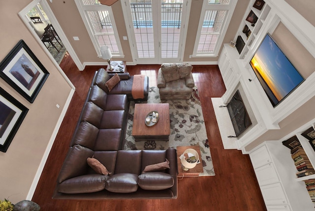 living room with plenty of natural light, dark hardwood / wood-style floors, and french doors