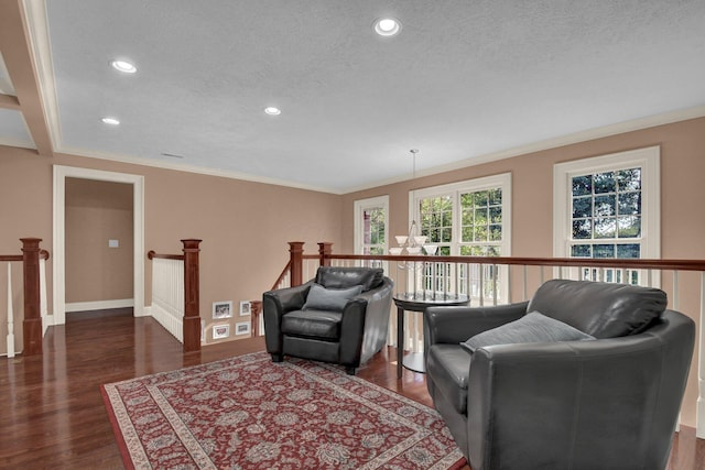 living room with dark wood-type flooring, ornamental molding, and a textured ceiling