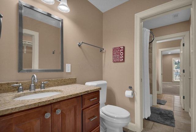 bathroom with tile patterned flooring, vanity, and toilet