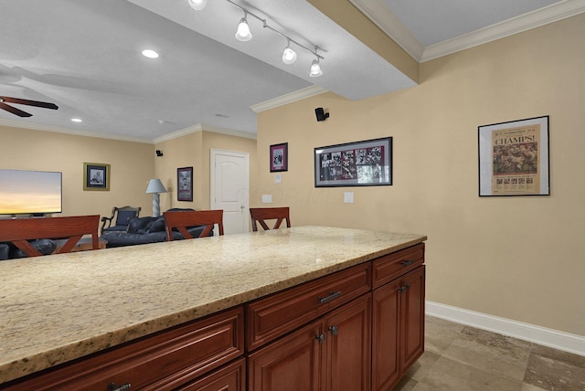 kitchen with light stone counters, crown molding, rail lighting, and ceiling fan